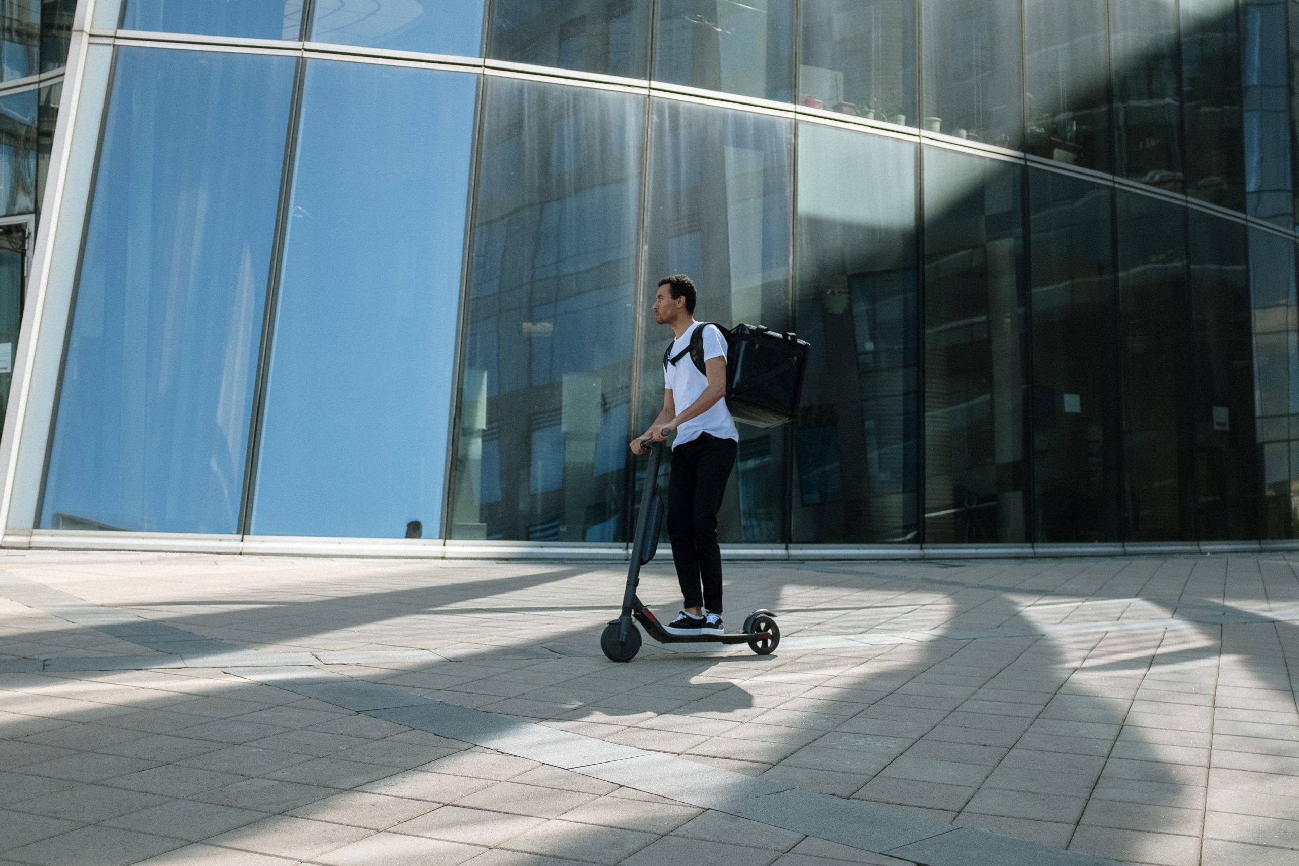 hombre en patinete eléctrico paseando con mochila